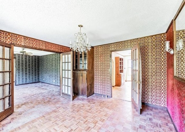 unfurnished dining area featuring french doors, a textured ceiling, and parquet floors