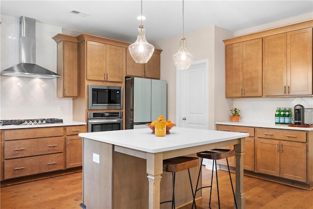 1835 Solamere Ct, Auburn, AL 36832 - kitchen with appliances with stainless steel finishes, wall chimney exhaust hood, tasteful backsplash, light countertops, and wood finished floors