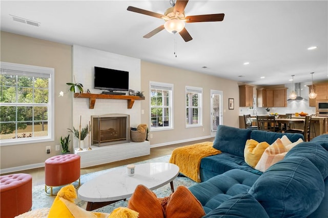 1835 Solamere Ct, Auburn, AL 36832 - living area with healthy amount of natural light, a brick fireplace, light wood-style flooring, a ceiling fan, and recessed lighting