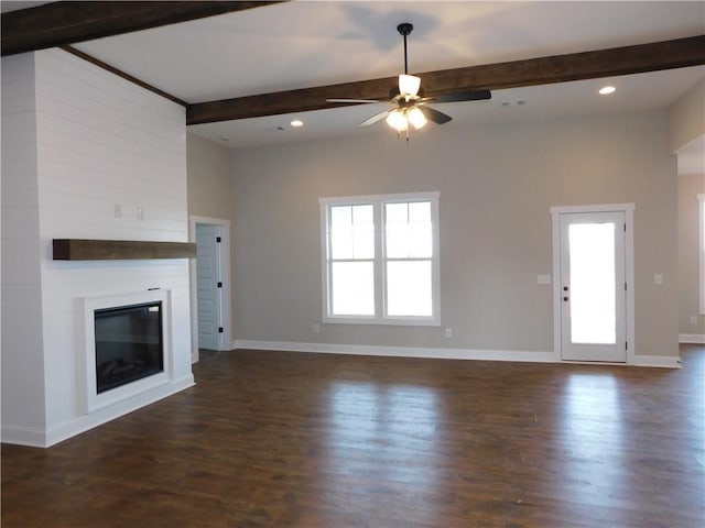 unfurnished living room featuring beam ceiling, a fireplace, dark hardwood / wood-style floors, and ceiling fan