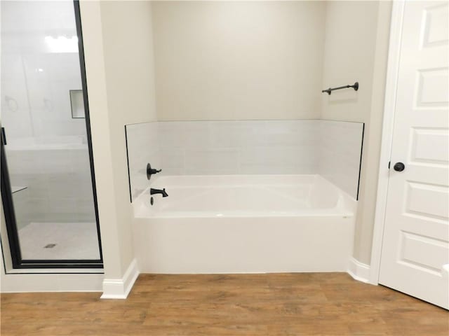 bathroom with independent shower and bath and hardwood / wood-style floors