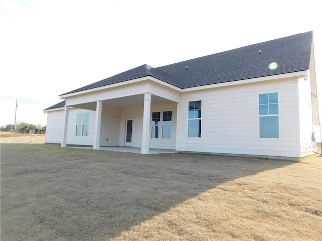 rear view of house featuring a patio area and a lawn