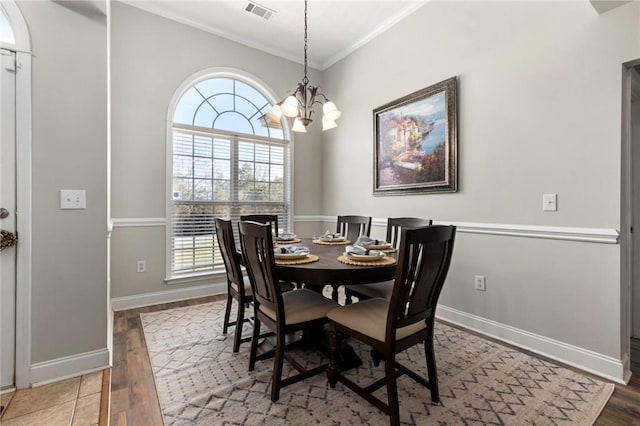 dining space with ornamental molding, wood finished floors, visible vents, and baseboards