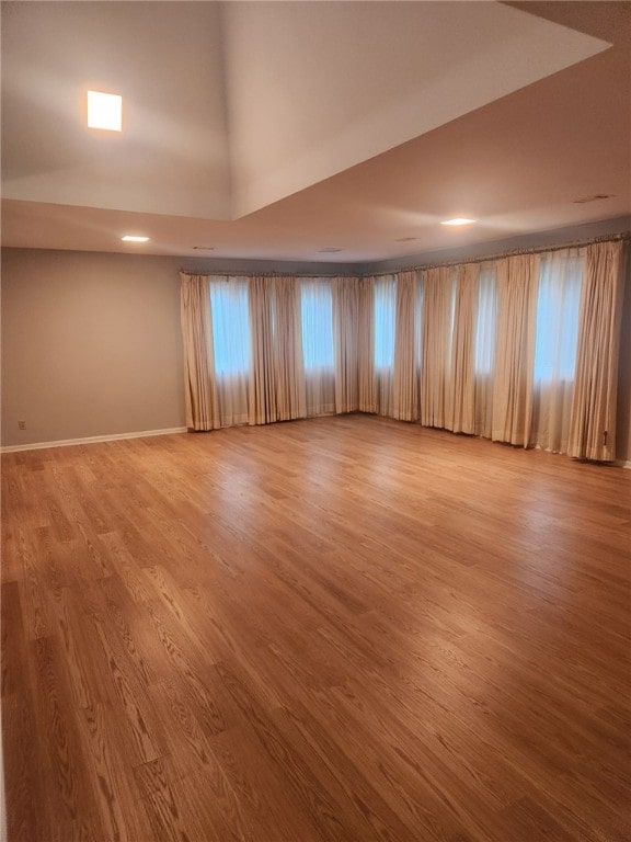 empty room with wood-type flooring and high vaulted ceiling