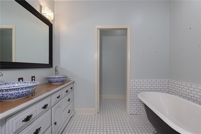 bathroom featuring tile patterned flooring, vanity, and a bath