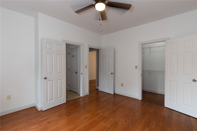 unfurnished bedroom with hardwood / wood-style floors, ceiling fan, and a closet