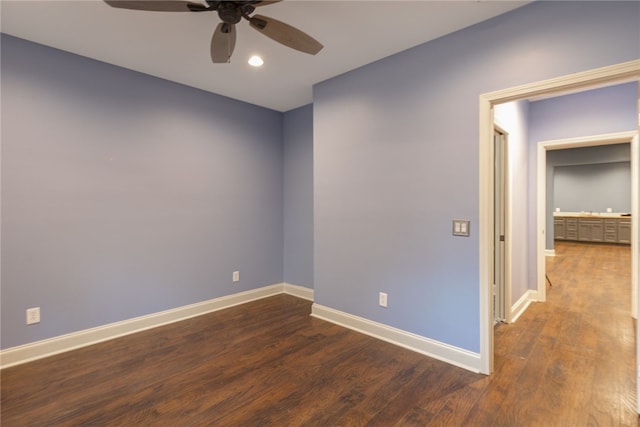 spare room with dark hardwood / wood-style floors and ceiling fan