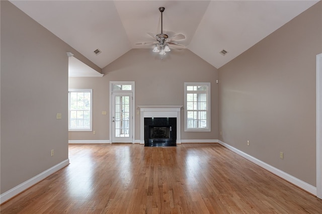 unfurnished living room with ceiling fan, plenty of natural light, vaulted ceiling, and light hardwood / wood-style flooring