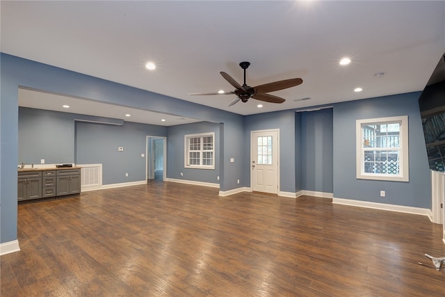 unfurnished living room with ceiling fan and dark hardwood / wood-style flooring