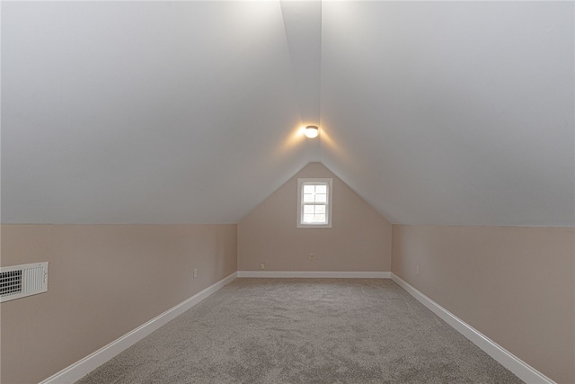 bonus room with light colored carpet and lofted ceiling