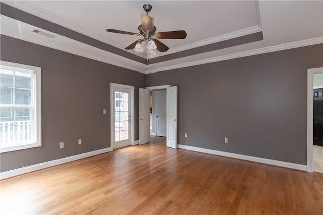 unfurnished room featuring ceiling fan, light hardwood / wood-style flooring, crown molding, and a tray ceiling