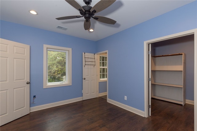 unfurnished bedroom featuring ceiling fan, dark wood-type flooring, and a closet