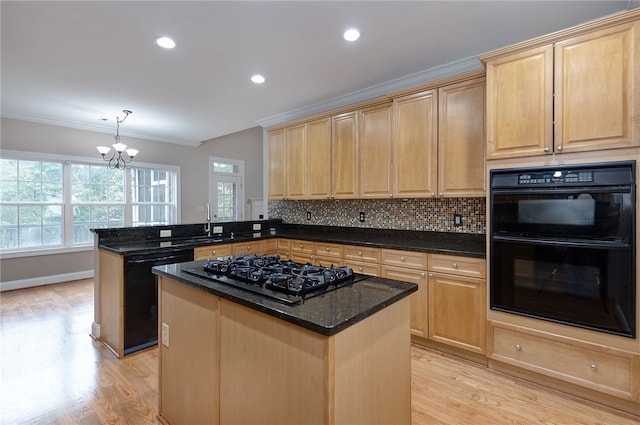 kitchen with kitchen peninsula, a center island, dark stone counters, and black appliances