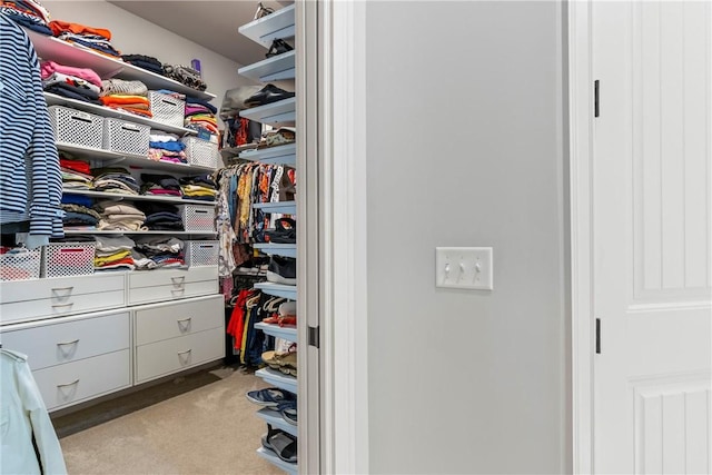 walk in closet featuring light colored carpet