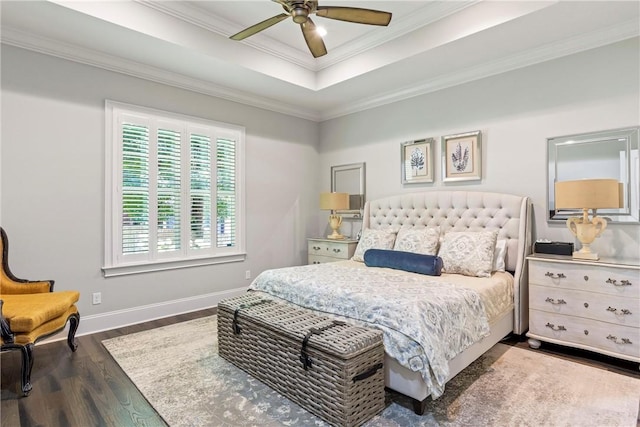 bedroom with ceiling fan, dark hardwood / wood-style floors, ornamental molding, and a tray ceiling