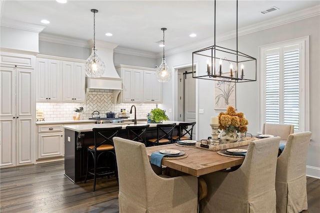 dining space featuring a healthy amount of sunlight, dark hardwood / wood-style flooring, ornamental molding, and sink