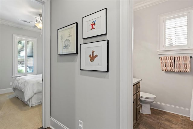 bathroom with ceiling fan, toilet, vanity, and ornamental molding