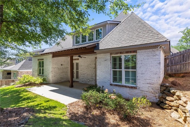 rear view of property with a lawn, ceiling fan, and a patio area