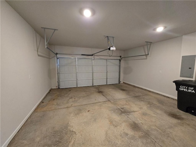garage with electric panel, a garage door opener, and baseboards