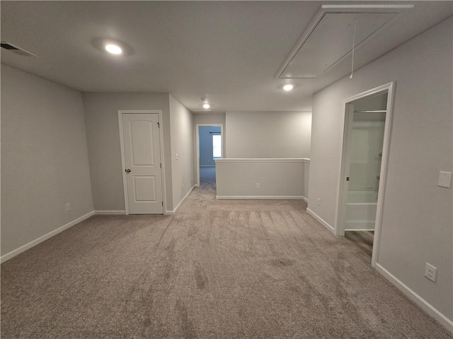 empty room featuring attic access, baseboards, visible vents, and carpet
