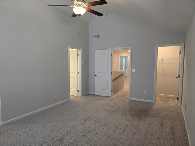 unfurnished bedroom with high vaulted ceiling, visible vents, baseboards, carpet floors, and a spacious closet