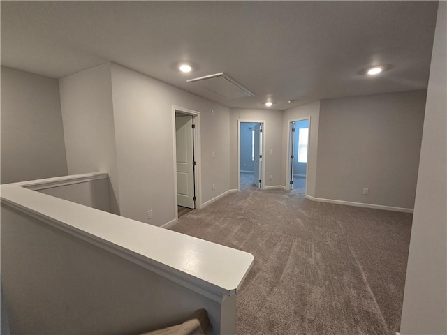 corridor with baseboards, carpet floors, recessed lighting, and attic access