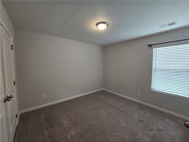 unfurnished room featuring baseboards, visible vents, and carpet floors