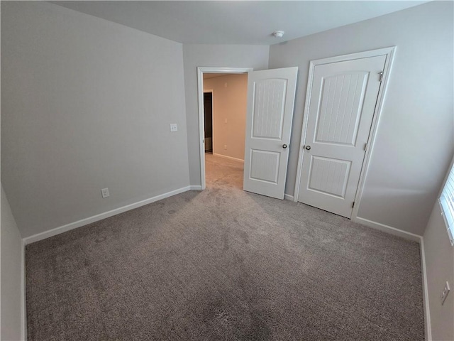 unfurnished bedroom featuring carpet and baseboards