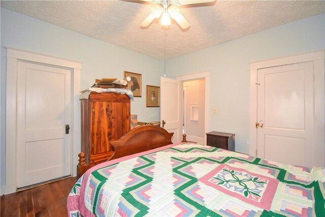 bedroom with dark wood-style floors, a textured ceiling, and ceiling fan