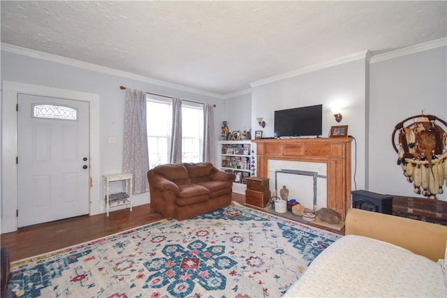 living room with ornamental molding, a fireplace, a textured ceiling, and wood finished floors