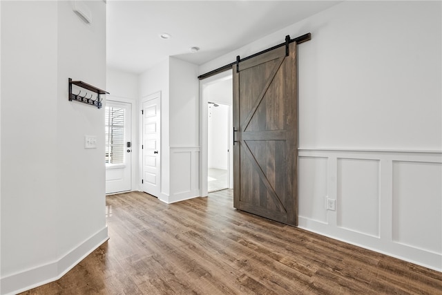 unfurnished room featuring hardwood / wood-style flooring and a barn door