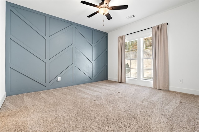 carpeted spare room featuring ceiling fan