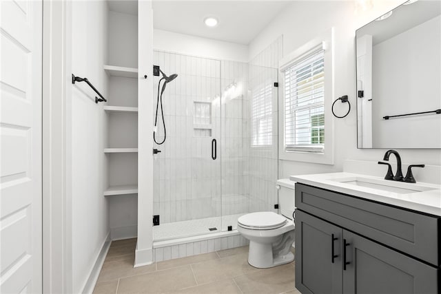 bathroom with vanity, a shower with shower door, tile patterned floors, and toilet