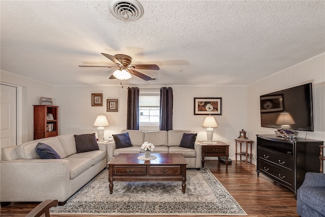 living area with dark wood-style floors, crown molding, visible vents, a ceiling fan, and a textured ceiling