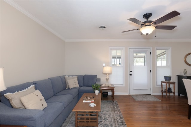 living room with baseboards, wood finished floors, visible vents, and crown molding