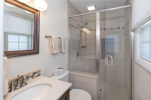 full bath with a stall shower, vanity, and toilet