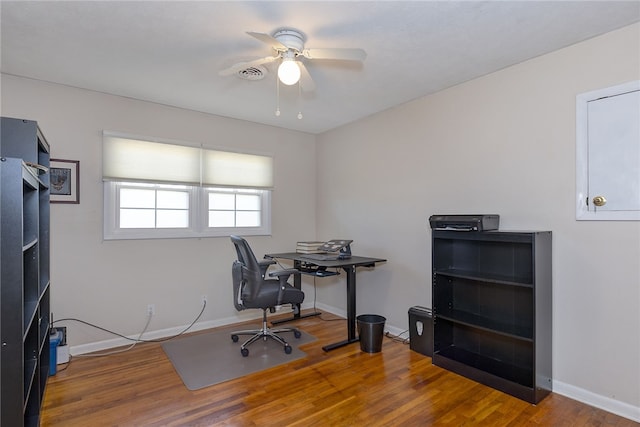 office area featuring ceiling fan, wood finished floors, visible vents, and baseboards