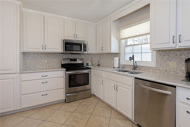 kitchen featuring stainless steel appliances, white cabinetry, a sink, and tasteful backsplash