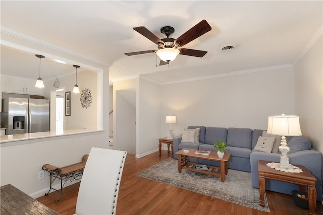 living room with ornamental molding, wood finished floors, and visible vents