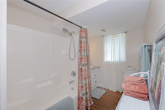 bathroom with visible vents, wood finished floors, toilet, and shower / bathtub combination with curtain