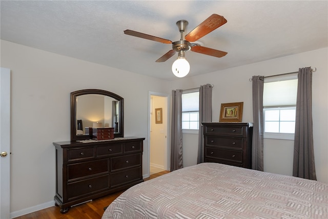 bedroom featuring dark wood-type flooring, ceiling fan, and baseboards