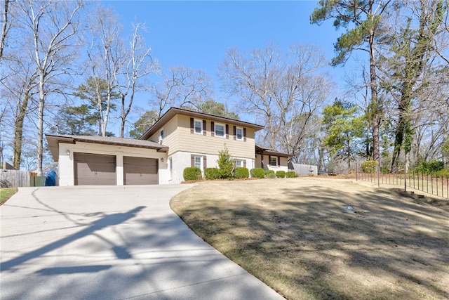 view of front of house featuring driveway, brick siding, an attached garage, and fence