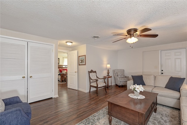 living room with a textured ceiling, wood finished floors, and visible vents