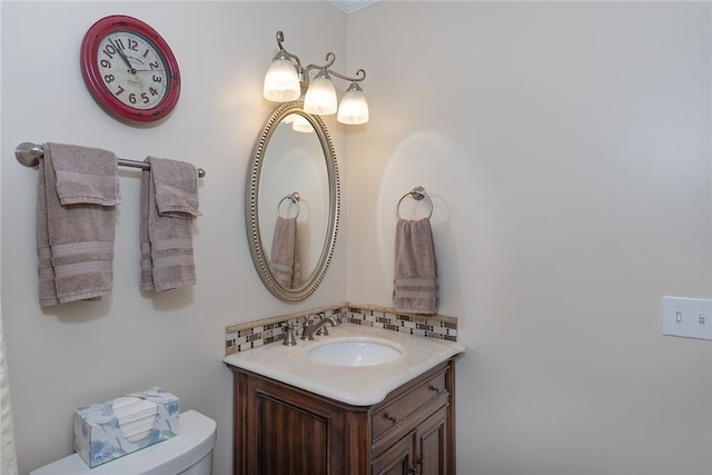 bathroom featuring decorative backsplash, vanity, and toilet