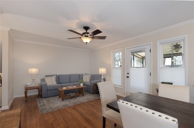 living area featuring a ceiling fan, baseboards, ornamental molding, and wood finished floors