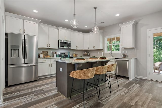 223 Meadowlark Dr, Smiths Station, AL 36877 - kitchen with decorative backsplash, appliances with stainless steel finishes, white cabinetry, and dark wood-type flooring