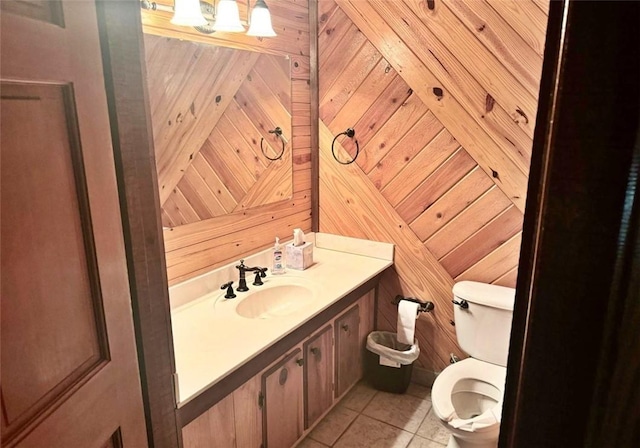 bathroom featuring tile patterned floors, wood walls, vanity, and toilet