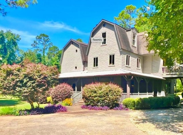 rear view of property featuring covered porch