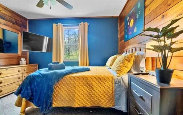 bedroom with wood walls and ceiling fan