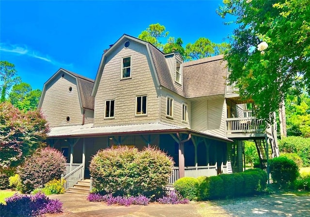 rear view of property featuring covered porch